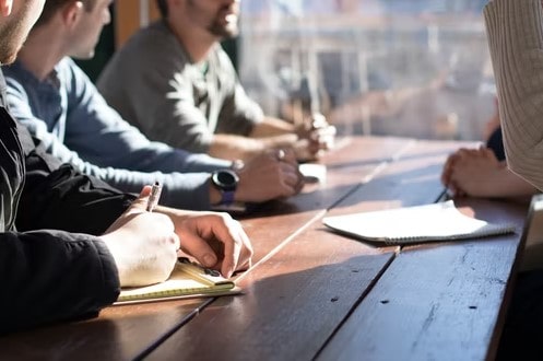 A team of office workers planning their next tasks due to outsourcing their secretarial services.